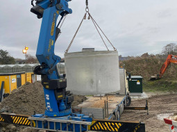 Hijsen regenwatertank vanaf de achterzijde van de vrachtwagen