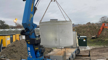 Hijsen regenwatertank vanaf de achterzijde van de vrachtwagen