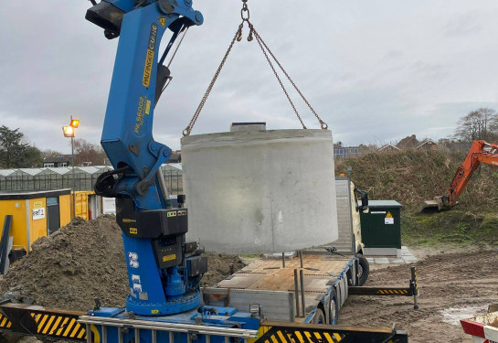 Hijsen regenwatertank vanaf de achterzijde van de vrachtwagen