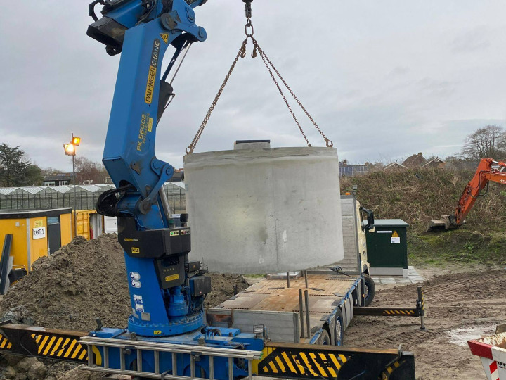 Hijsen regenwatertank vanaf de achterzijde van de vrachtwagen
